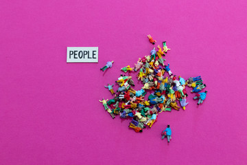PEOPLE word and miniature people mixed and grouped together chaotically on a bright pink...