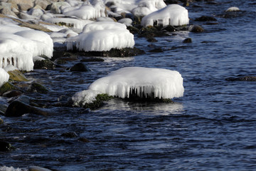 Icy stones on coast. Winter seascape