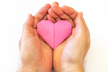 Obraz premium 折り紙で作ったハートを持つ男の手