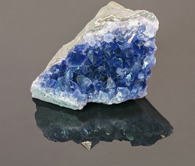 blue sapphire in geode on grey background