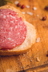 Bread with salami on the wooden background. Shallow depth of field.