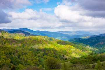 rural landscape in mountains. dappeled light on forested hills. beautiful nature scenery in spring. wonderful weather with clouds