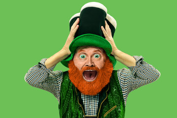 Astonished, shocked. Excited leprechaun in green suit with red beard on green background. Funny...