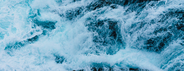 White sea foam produced when the waves collide with the rocks of the coast