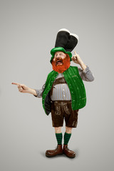 Pointing. Excited leprechaun in green suit with red beard isolated on white background. Funny...