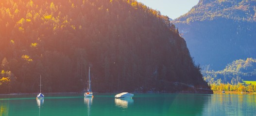 Wolfgangsee lake in the Austrian Alps by sunset in the summer day. Clear turquoise water with boats, mountains on blue sky background. Salzkammergut resort region in Upper Austria, Salzburgerland.