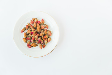 Rose herbal tea.Small dried rose on the plate.White background.Minimalist style.Copy space