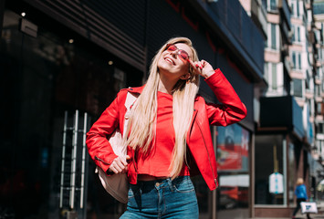 Fototapeta premium Happy girl walks down the street in spring around the city