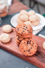 Oatmeal cookies and biscuits on a wooden cutting board on a blue table. Top view