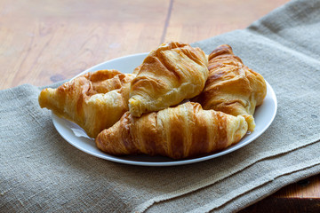 French mini croissants in a white plate on canvas
