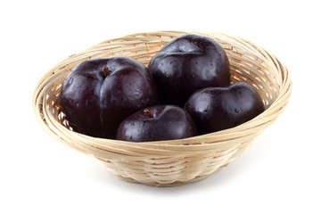 Plums on wicker plate