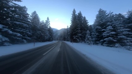 FRONT DRIVING PLATE Car driving on road through snowy landscape towards mountains 