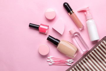 makeup kit. Women's cosmetics in a cosmetic bag and makeup brushes on a pink bright background. women things. top view