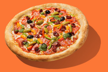 Italian pizza with vegetables, with slices of salami and with pesto, levitate, cast a shadow, on an orange background, concept, in sharp colors