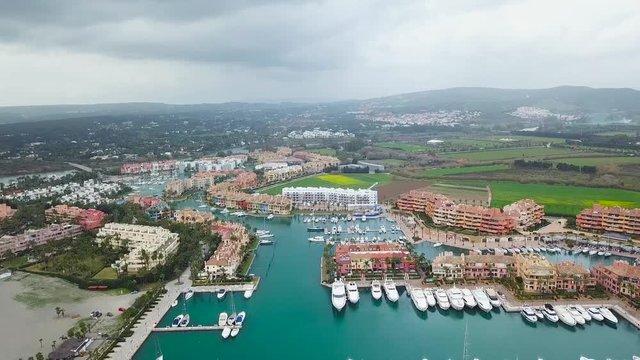Unique generic aerial view of exclusive Sotogrande Bay - Costa del Sol. Cloudy day and rainy , beautiful sky colours. Luxury real estate and yacht. Famous location. 