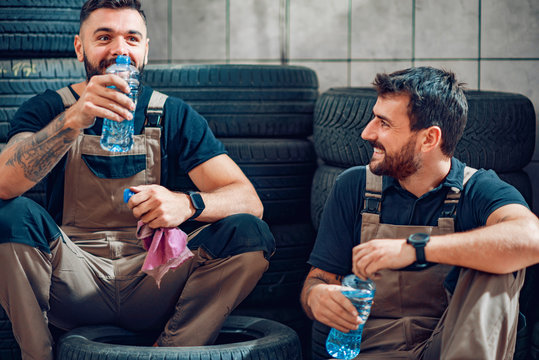 Two mechanics in uniform are working in auto service