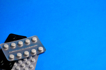 Pills in a blister at classic blue background with copy space