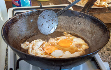 FRIED EGGS MADE IN A PAN WITH OLIVE OIL TO SHARE WITH FRIENDS AT A LUNCH
