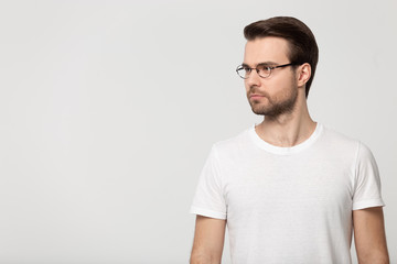 Fototapeta premium Serious concentrated young guy standing aside free copy space.
