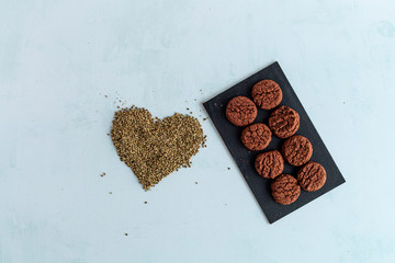 CBD cannabis cookies, cocoa and heart shaped hemp seeds on bright background. Medicinal marijuana...