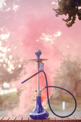 Fototapeta premium Hookah outdoors on a background of colored smoke