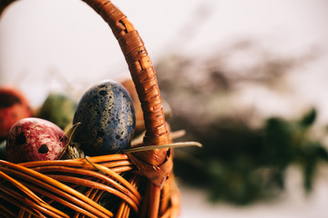 Easter eggs in a basket on a white wooden background