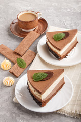 Cake with souffle milk chocolate cream with cup of coffee on a gray concrete  background. side view.