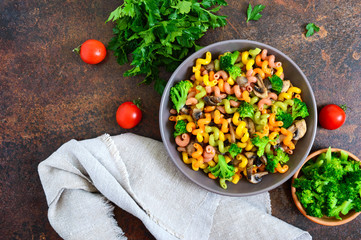 Cavatappi colored pasta with broccoli and mushrooms. Pasta colorata. Pasta with vegetables. The top view
