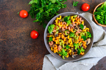 Cavatappi colored pasta with broccoli and mushrooms. Pasta colorata. Pasta with vegetables. The top view