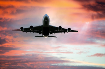 Naklejka premium Silhouette of Airplane after take off from the airport, skyward view at sunset