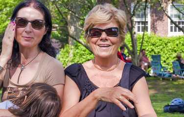 Happy elderly grandmother with daughter and grand daughter enjoying city park in summer season