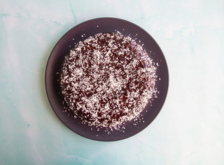 Pumpkin pie with chocolate syrup and coconut shavings
