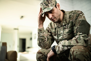 Young army soldier feeling depressed and thinking of something.