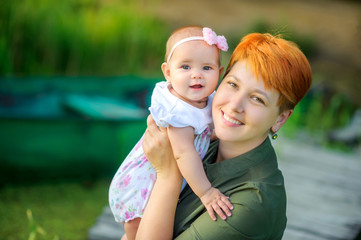 Happy family. Mom with her beloved daughter is resting in a beautiful park at sunset, family time.