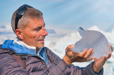 Scientist examining small iceberg in Jokulsarlon Glacier Lagoon