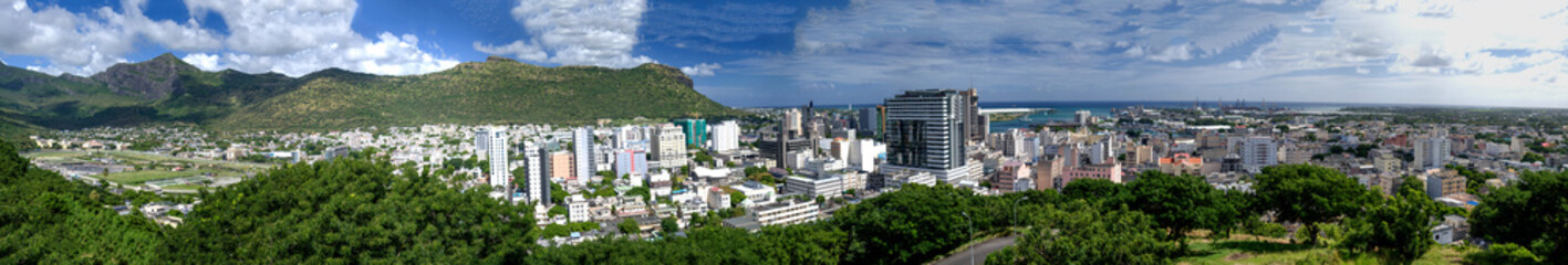 Fototapeta premium PORT LOUIS, MAURITIUS - APRIL 28, 2019: Panoramic aerial city view with buildings and vegetation