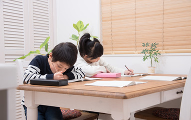 ダイニングで勉強をする小学生の子供