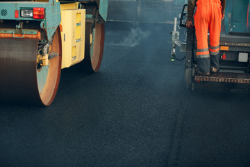 Asphalt paving. Paver machine and road roller. New road construction.