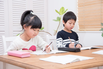 ダイニングで勉強をする小学生の子供