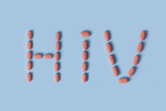 hiv therapy pills on pink background.