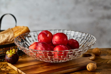 Red plums in a glass fruit plate