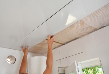 PVC Ceiling Panels, Cladding Installation. Builder installing, renovate, repair white PVC Ceiling...