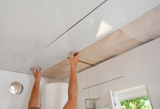 PVC Ceiling Panels, Cladding Installation. Builder installing, renovate, repair white PVC Ceiling Boards in the bathroom