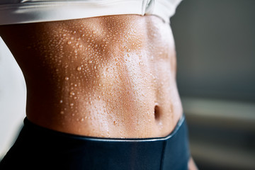 Fototapeta na wymiar Close up of fit woman torso with sweat on skin after workout