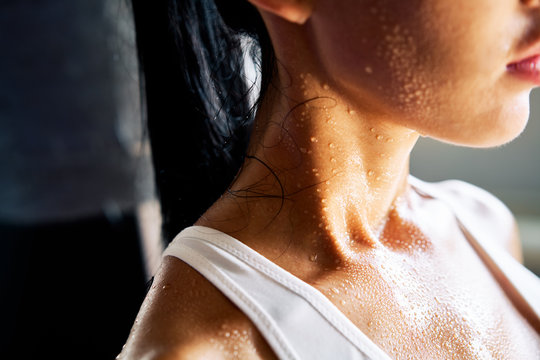 Close up shoulders and neck of sporty girl in drop of sweat on skin after workout