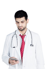 Fototapeta premium Young doctor typing message on mobile phone