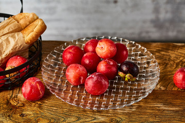 Red plums in a glass fruit plate