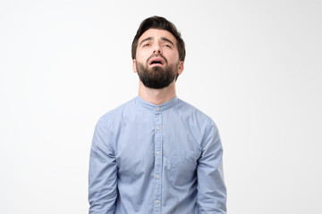 Young gloomy man with beard pouting and crying, standing upset and depressed