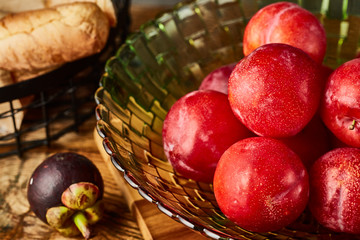Red plums in a glass fruit plate