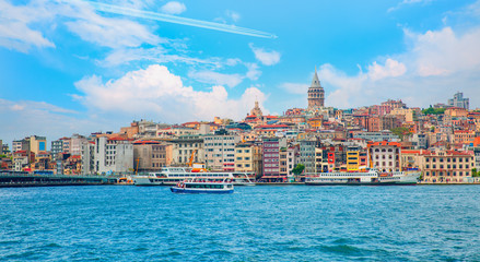 Obraz premium Trail of white smoke from the airplane on blue sky - Galata Tower, Galata Bridge, Karakoy district and Golden Horn at bright blue sky - Istanbul, Turkey